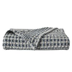 a black and white checkered blanket on top of a bed next to a pillow