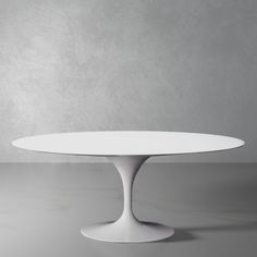 an oval white table sitting on top of a gray floor