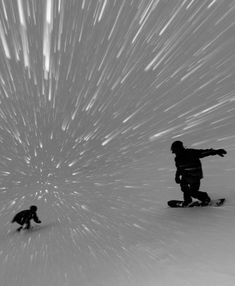 two snowboarders are going down a hill with the stars in the sky above them