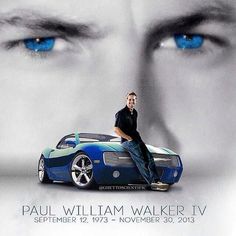 a man sitting on top of a blue sports car in front of a movie poster