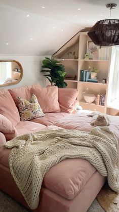 a living room with pink couches and bookshelves