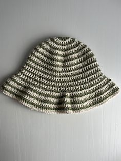 a crocheted hat sitting on top of a white table next to a wall