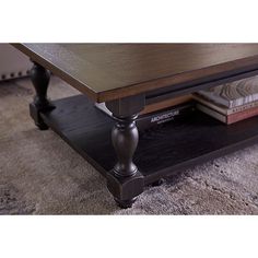 a coffee table sitting on top of a carpeted floor next to a book shelf