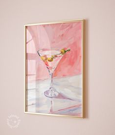 a painting hanging on the wall next to a wine glass with olives in it