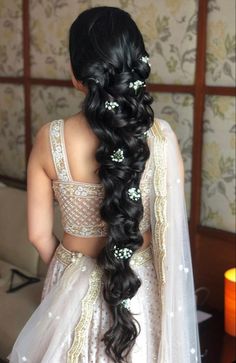 the back of a bride's head with long hair and flowers in her hair