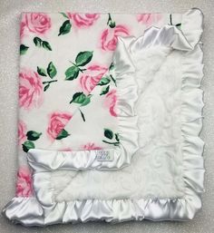 two pieces of white and pink fabric with roses on the bottom one is folded in half