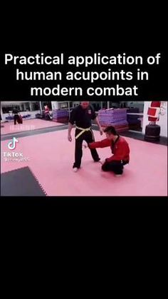 two people are practicing martial in an indoor area with pink flooring and black walls