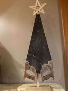 a wooden christmas tree on display in a room with scissors and other items around it