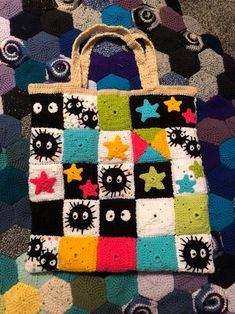 a multicolored handbag sitting on top of a carpet covered in crochet