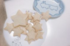 some cookies are on a white plate and one is shaped like a train with stars
