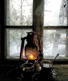 an old fashioned tea kettle sitting in front of a window