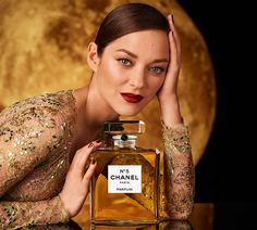 a woman posing next to a bottle of chanel perfume