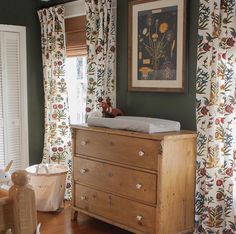 a baby crib in the corner of a room next to a window with curtains