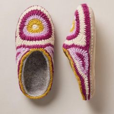 a pair of crocheted slippers sitting on top of a white surface