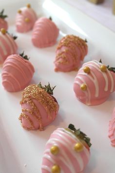 pink and gold strawberries are arranged on a white platter
