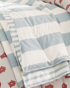 an unmade bed with blue and white sheets, red arrows on the comforter