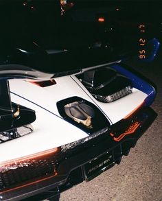 a white and blue sports car parked on the street