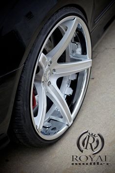 the front wheel of a black car with chrome spokes