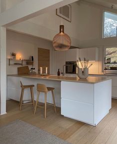 a kitchen with two stools next to an island