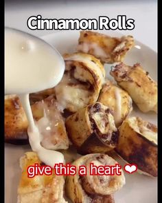 cinnamon rolls being drizzled with icing on a plate