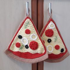 two crocheted pizza slices hanging from hooks