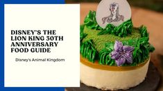 the lion king 30th anniversary food guide is displayed on a cake with green frosting and purple flowers