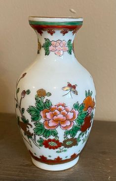 a white vase with flowers painted on it