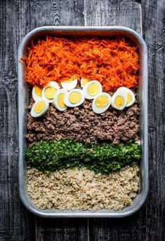 an image of food in a container with eggs and carrots