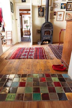 a room with a wood stove and rugs on the floor