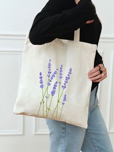 a woman carrying a tote bag with lavender flowers on it