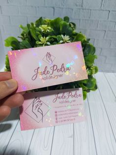 a person holding up a business card with glitter on it