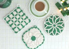 three crocheted coasters sitting on top of a white tile counter next to a cup of coffee