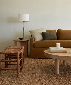 a living room filled with furniture and a lamp on top of a wooden coffee table