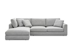 a gray sectional couch with pillows on the top and bottom corner, facing away from the camera