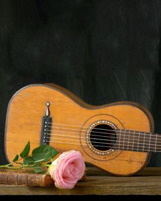 an old ukulele with a pink rose on it