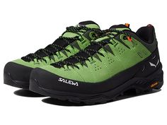 a pair of green and black shoes on a white background with the word salewa written below them