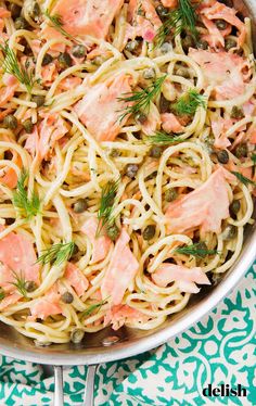 a pan filled with pasta, salmon and capers