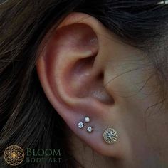 a woman's ear with three different piercings