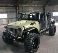 a green jeep parked inside of a garage