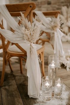 a chair and some candles on a wooden floor with white draping around it