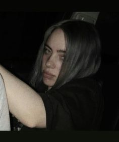 a woman sitting in the back seat of a car with her arm around someone's shoulder