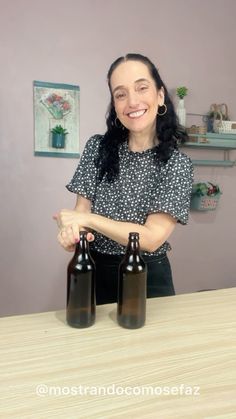 a woman standing behind three brown beer bottles