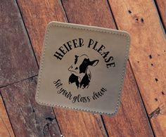 a leather coaster with the words help please and a cow's head on it