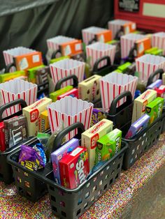 several baskets filled with candy and snacks on top of a table covered in confetti