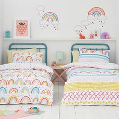 two twin beds with rainbows and clouds on the wall