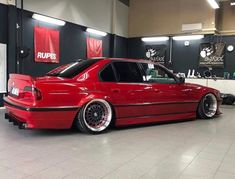 a red car is parked in a showroom