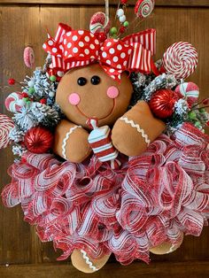 a christmas wreath with a teddy bear hanging from it