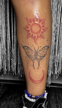 a tattoo on the leg of a person with a butterfly and sun in it's wings