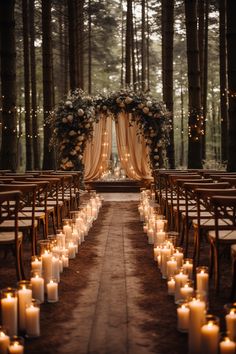 an outdoor wedding setup with candles and draping on the aisle, surrounded by tall trees