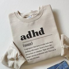 This ADHD definition sweatshirt is a delightful fusion of comfort, style, and awareness. With its vibrant design and witty neurodiversity-themed message, it serves as the perfect inclusion shirt and a thoughtful gift for her, promoting mental health awareness with a touch of humor. ADHD definition sweatshirt, Funny adhd shirt, Neurodiversity sweater, Inclusion sweatshirt, adhd gift,Awareness shirt,Mental health gift ✧ Crewneck sweatshirt - Material and sizing ✧ 50% cotton, 50% polyester Medium-heavy fabric  Loose fit Sewn-in label Runs true to size Size up for an oversized look ✧ Quick Sizing Tip ✧ Our sweatshirts are a fantastic fit. Women who prefer an oversized look should order one size up. ✧ PRODUCTION & SHIPPING Time ✧ Our TShirts and Sweatshirts are handmade to order Production time Affirmation Clothing, Funny T Shirt Sayings, Thoughtful Gifts For Her, Cute Shirt Designs, Quirky Fashion, Awareness Shirt, Funny Hoodies, Birthday Wishlist, Funny Sweatshirts